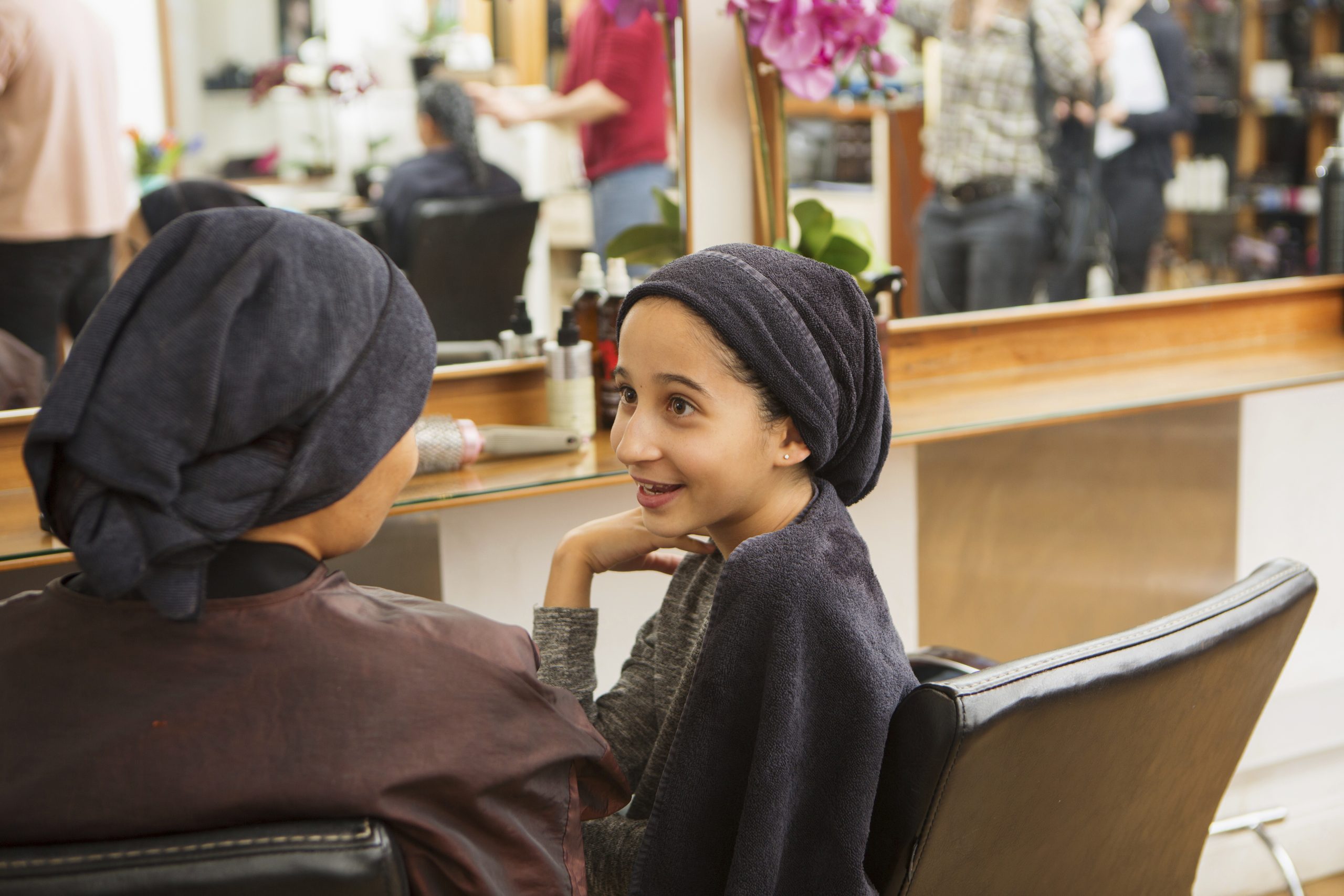 Young girl having a heartfelt conversation at the hair salon.